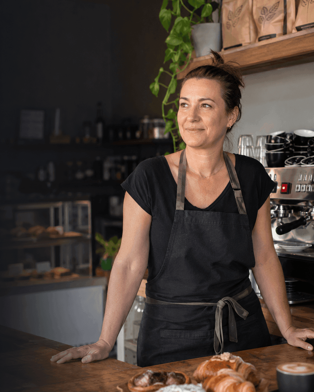 A New Zealand café owner standing behind her counter